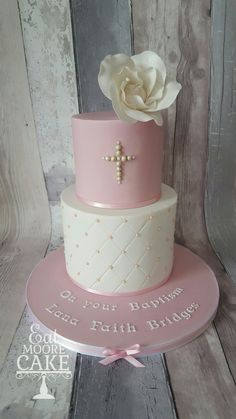 a pink and white cake with a cross on top