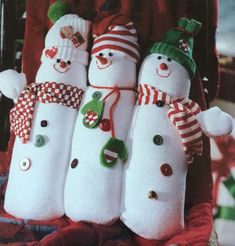 three snowmen with hats and scarves on their heads are hanging from a chair