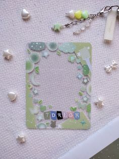 a photo frame with the word dream written on it, surrounded by beads and other items