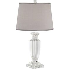 a clear glass table lamp with a grey shade on it's base and a light gray linen shade on the bottom