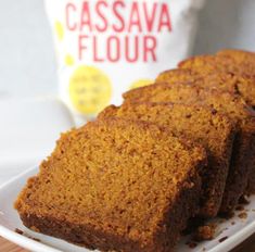 slices of pumpkin bread on a white plate next to a bag of floured milk