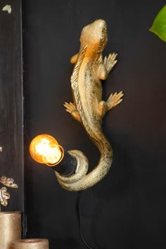 a lamp that is sitting on top of a table next to a wall mounted lizard