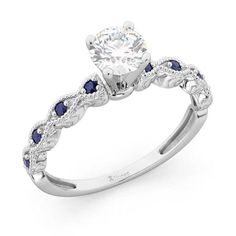 an engagement ring with blue sapphire stones on the sides and a diamond center stone in the middle