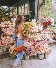 a woman standing in front of a flower shop