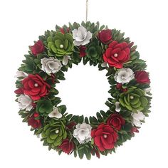 a christmas wreath with red, white and green flowers hanging from the front of it