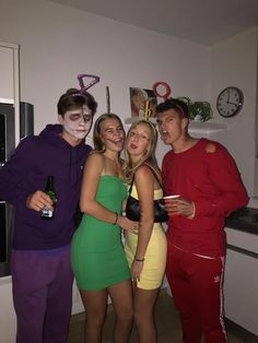 three people dressed up in costumes posing for a photo with one person holding a beer