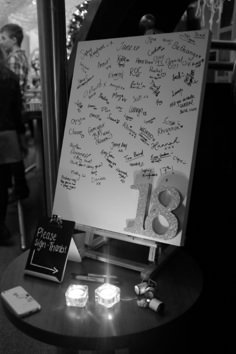 a white board with writing on it sitting on a table next to candles and other items