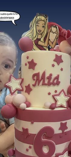 there is a small child standing next to a large cake with stars on the side