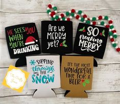 four christmas cards with sayings on them sitting next to a string of pom - poms