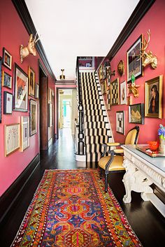 the hallway is decorated in pink and black with pictures hanging on the wall above it