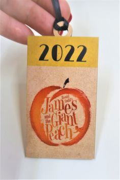 a hand holding a piece of paper with the words james and giant peach on it