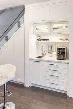 a kitchen with white cabinets and counter tops