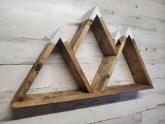 a wooden shelf with three triangles on it