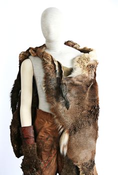 a mannequin with fur and leathers on it's back, standing in front of a white background