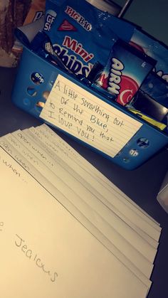 a pile of papers sitting on top of a desk next to a bag of chips