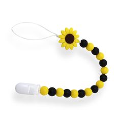 a yellow and black beaded necklace with a sunflower on the end is attached to a white cord