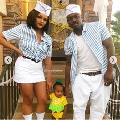 a man and woman are standing on the steps with a baby in front of them