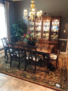 a dining room table and chairs with a rug on the floor