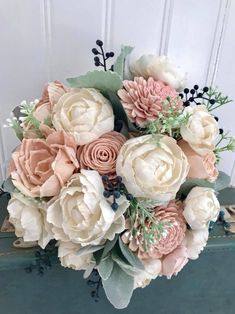 a bouquet of flowers sitting on top of a wooden table next to a white door