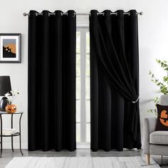 a living room filled with furniture and black curtains