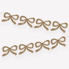 two brown bows with glitter on them hanging from clothes pins in front of a white background