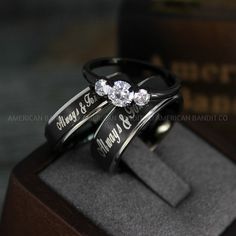 two wedding rings with the words happy and merry on them sitting on top of a box