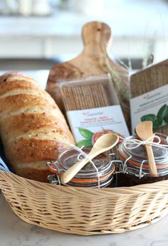 a basket filled with bread and jams on top of a table