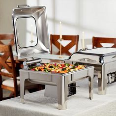 a buffet table set up with food and silver serving trays on top of it