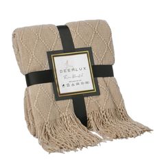 a beige blanket with black ribbon on the side and a label that says deerlox