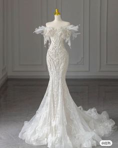 a white wedding dress on a mannequin in front of a wall and floor