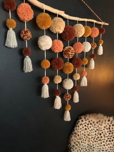 a wall hanging with pom poms and tassels