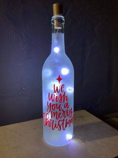 a lighted bottle that says we wish you a merry christmas on the front and side