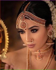 a woman wearing an elaborate head piece and jewelry