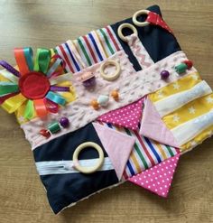 a wooden table topped with lots of colorful pieces of cloth and toys on top of it