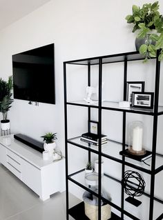 a living room filled with furniture and a flat screen tv mounted on the wall above it