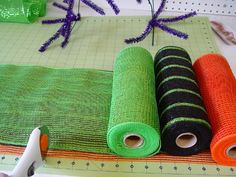 three rolls of yarn sitting on top of a table next to some scissors and spools