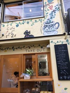 there is a man that is standing in front of the coffee shop with flowers on it