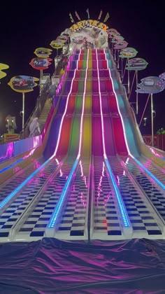 an illuminated carnival ride at night with people on it