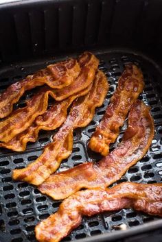 bacon is being cooked in an outdoor grill