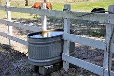 there is a horse behind the fence drinking out of it's water buckets