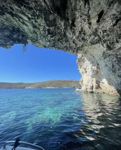 there is a boat in the water near a cave