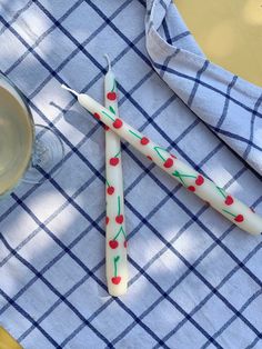 two toothbrushes sitting on top of a blue and white checkered table cloth