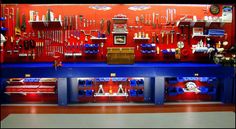 a room filled with lots of different tools and equipment on display in front of a red wall