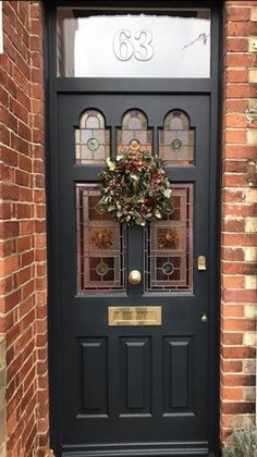 a black front door with a wreath on it