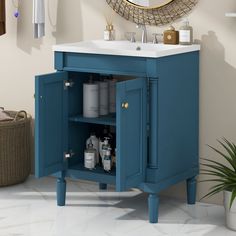 a bathroom vanity with blue cabinet and white sink