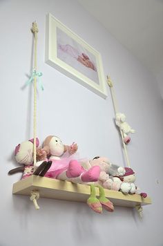 stuffed animals are sitting on a wooden swing