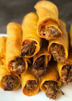 several pieces of food on a plate with meat and cheese wrapped in tortilla wrappers