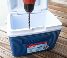 a drill is being used to make a hole in a cooler