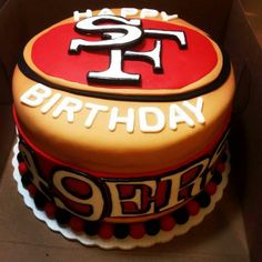 a birthday cake in the shape of a san francisco giants logo on top of a cardboard box