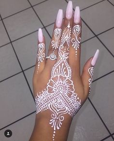 henna on someone's hand with pink and white nail polish, it looks like they